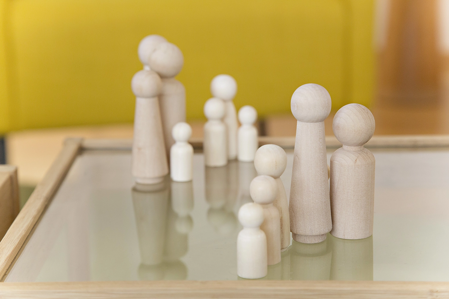 Holzfiguren auf einem Tisch, symbolisch für Aufstellung oder Gemeinschaft